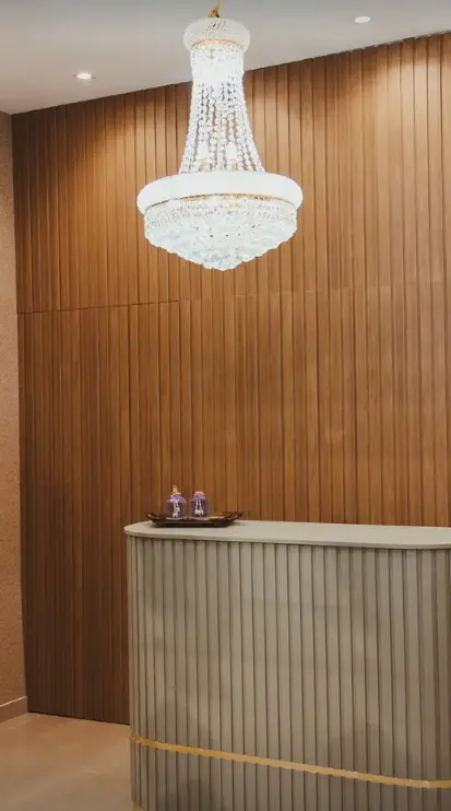 Recepção da Lavanda Boutique Spa com painel de madeira, balcão e lustre